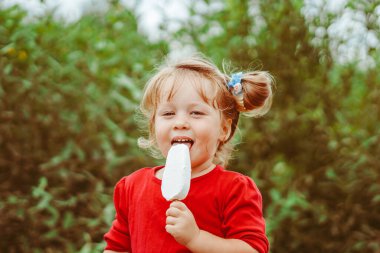 Küçük güzel sarışın kızın elinde beyaz dondurma.