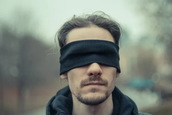 Een man met een zwarte blinddoek over zijn ogen — Stockfoto