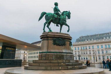 30 Mayıs 2019 Viyana, Avusturya - Albertina Müzesi 'nin dışındaki Arşidük Albrecht Heykeli. Arka planda bulutlu gökyüzü, Viyana Devlet Operası (Wiener Staatsoper).