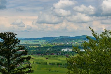 Neuschwanstein kalesi ve Hohenschwangau kalesi yakınlarındaki Alp ormanları. Bahar zamanı Bavyera Alpleri, Tegelberg Dağı.