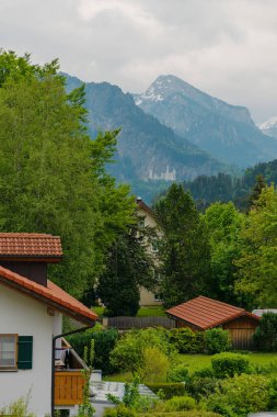 26 Mayıs 2019 Fussen, Almanya - Neuschwanstein kalesi yakınlarında küçük bir kasaba. Dağlarda kırmızı kiremit çatıları olan küçük dağ tebeşirleri. Derli toplu bahçeler