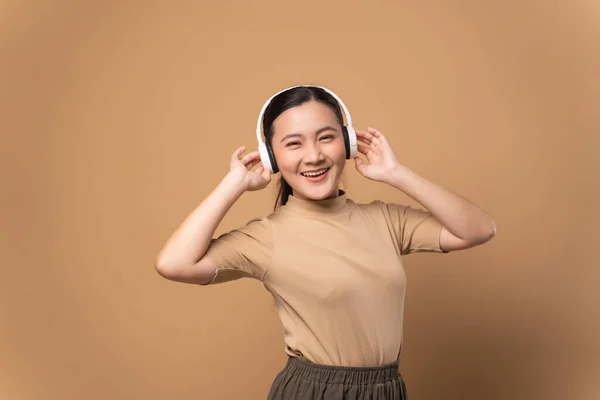 Lycklig Kvinna Med Hörlurar Och Lyssna Musik Isolerad Beige Bakgrund — Stockfoto