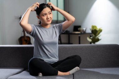 Asyalı kadın hastaydı, derisi kaşınıyordu, tenini kaşıyordu, evdeki oturma odasında kanepede oturuyordu..