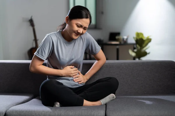 Asian Woman Touching Her Belly Sick Stomachache Sitting Sofa Living — Stok fotoğraf