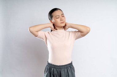 Asyalı kadın vücuduna dokunduğu için hastaydı ve beyaz arka planda tek başına duruyordu..