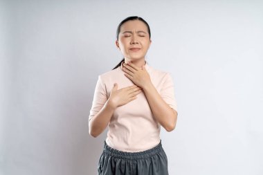 Asian woman was sick with sore throat, coughing sneezing and standing isolated on white background.