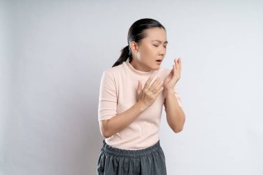 Asian woman was sick with sore throat, coughing sneezing and standing isolated on white background.