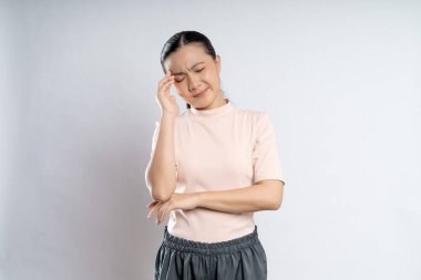 Asian woman was sick with headache touching her head and standing isolated on white background.