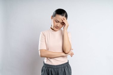 Asian woman was sick with headache touching her head and standing isolated on white background.
