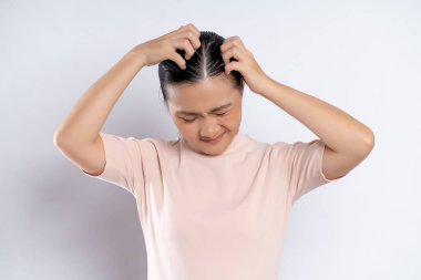 Asian woman was sick with irritate scratching her head, standing isolated on white background.