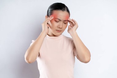 Asian woman was sick with headache touching her head with red spot and standing isolated on white background.