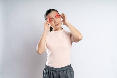 Asian woman was sick with headache touching her head with red spot and standing isolated on white background.