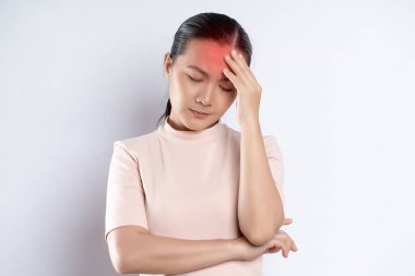 Asian woman was sick with headache touching her head with red spot and standing isolated on white background.