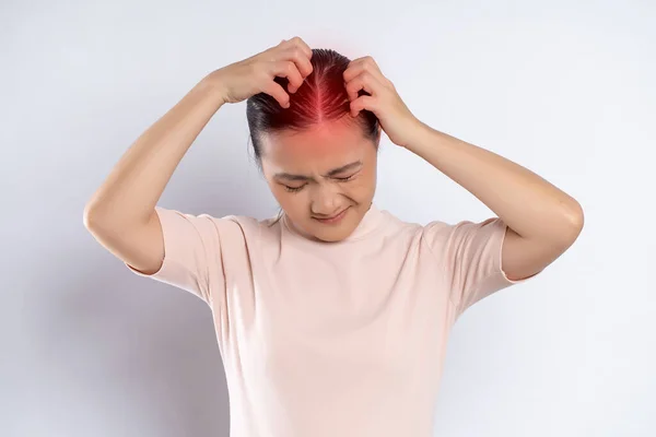 Asian woman was sick with irritate scratching her head with red spot standing isolated on white background.