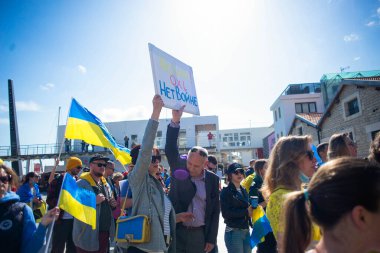 Limassol, Cyprus - March 5 2022: people with Ukrainian flags and anti war placards protest against russian aggression in Ukraine clipart