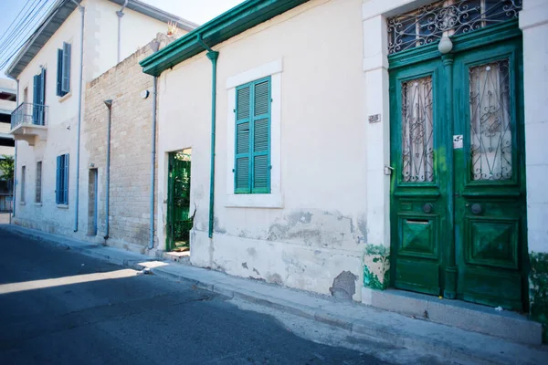 Kıbrıs 'ın Limasol kentindeki eski yeşil ve mavi kapı ve pencereli tarihi cadde