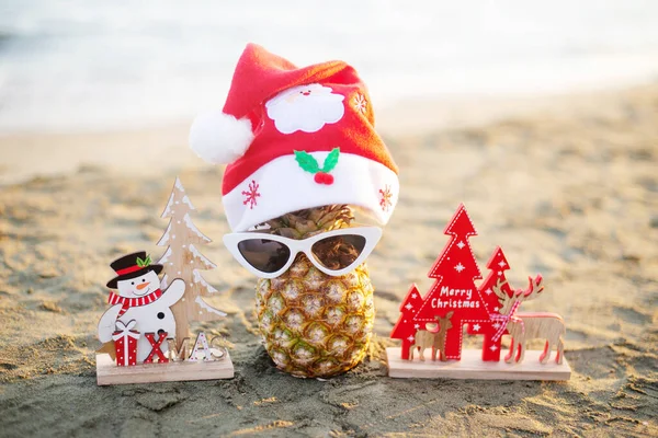 Ananas Mit Sonnenbrille Und Weihnachtsdekoration Strand Bei Sonnenuntergang Weihnachtsferien Konzept — Stockfoto