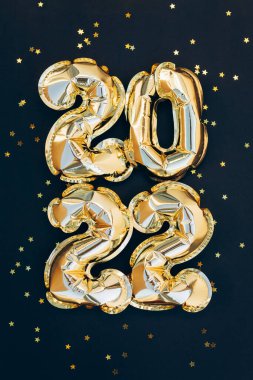 Moda arka planında 2021 altın madalya tatili. Parlak parti geçmişi. Altın folyo balonları 2022 sayılı, parıltılı altın konfetiyle. Mutlu yıllar kartı.