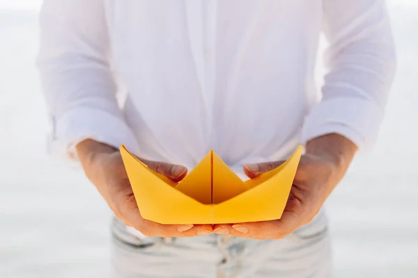 Mano Femenina Con Barco Papel Amarillo Sobre Fondo Del Mar —  Fotos de Stock