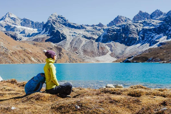 Adventures woman with mountain peaks background. Girl hiking in mountains. Happy traveler enjoying the view