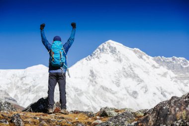 Yürüyüşten sonra gökyüzünde yükselen kollarıyla neşeli ve mutlu bir yürüyüşçü. Everest Dağı arka planda - dünyanın en yüksek zirvesi