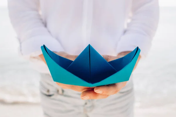 Main Féminine Avec Bateau Papier Bleu Sur Fond Mer — Photo