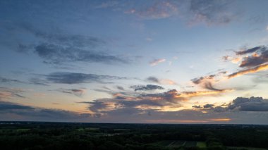 Gün doğumunda ya da batımında İHA ile çekilen gök gürültülü fırtına bulutlarıyla kaplanmış bir akşam gökyüzünün havadan görünüşü.