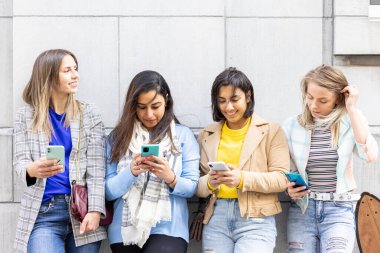 Çok ırklı gençlerden oluşan bir grup akıllı telefonlarla mutlu mesut oynarken eğleniyor. Bin yıllık cep telefonları ve sosyal uygulamalara göre kullan. 