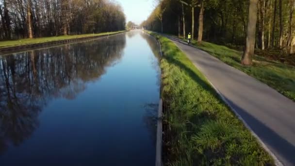 Drönare flyger lågt över floden eller kanalen och skogen i Belgien — Stockvideo