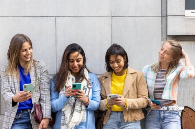 Çok ırklı gençlerden oluşan bir grup akıllı telefonlarla mutlu mesut oynarken eğleniyor. Bin yıllık cep telefonları ve sosyal uygulamalara göre kullan. 