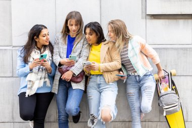 Çok ırklı gençlerden oluşan bir grup akıllı telefonlarla mutlu mesut oynarken eğleniyor. Bin yıllık cep telefonları ve sosyal uygulamalara göre kullan. 