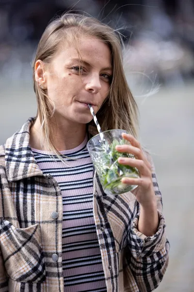 Όμορφη ελκυστική νεαρή καυκάσια γυναίκα ή εικοσάρης κορίτσι πίνοντας κρύο μοχίτο με άχυρο στο κέντρο της πόλης κατά τη διάρκεια happy hour — Φωτογραφία Αρχείου