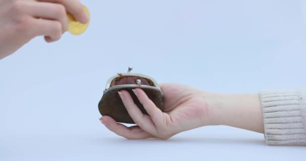 Tangan laki-laki menempatkan cryptocoin, Bitcoin atau BTC, dalam dompet cokelat kecil, yang menggambarkan penghasilan atau membayar dengan crypto atau cryptocurrency dan tabungan, memegang atau mencangkul — Stok Video