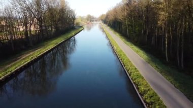 İnsansız hava aracı Belgie 'de nehir, kanal ve orman üzerinde alçaktan uçuyor.