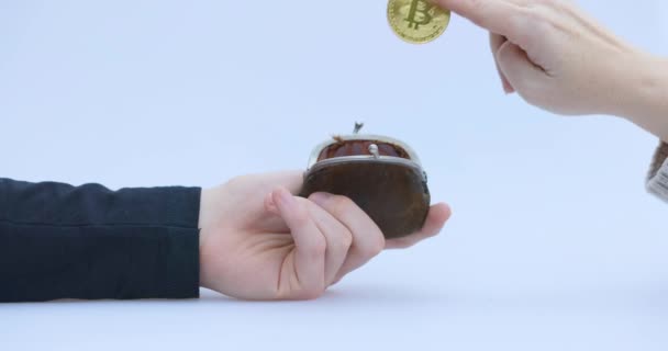 Αρσενικό χέρι βάζει ένα cryptocin, Bitcoin ή BTC, σε ένα μικρό καφέ πορτοφόλι, που απεικονίζει κερδίζοντας ή πληρώνοντας με crypto ή cryptocurrency και την εξοικονόμηση, κατοχή ή πρόσδεση — Αρχείο Βίντεο