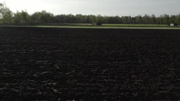 Luchtfoto van een omgeploegde landbouwgrond op het open platteland op een zonnige dag — Stockvideo