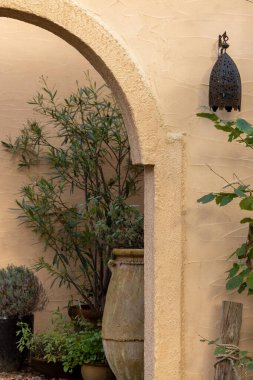 Kemerleri ve turizm dekorasyonları olan tipik bir ortadoğu mimari binasının duvarında Arap tarzı lamba. 