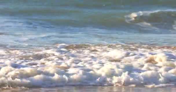 Slow Motion - Okyanus dalgası n cyan deniz suyu beyaz köpükle güneşli mavi gökyüzünde arka planda tropikal yaz kumlu plajlarda güneşli bir günde ada cennetinde, b-roll video görüntüleri — Stok video