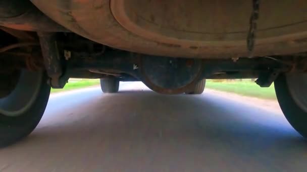 Roda traseira do caminhão SUV girando e mover-se em terreno off road com terra suja crepúsculo e tremer embaçado — Vídeo de Stock
