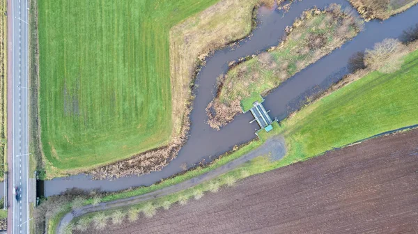 Vista dall'alto verso il basso, ripresa con un drone del Paesaggio con strada e ponti sul fiume Aa, Erzegovina, Belgio, che corre tra i campi coltivati — Foto Stock