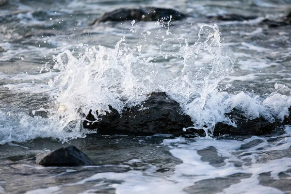 Las olas del mar golpean rocas en la playa con agua de mar turquesa causando salpicaduras de agua. Increíble paisaje marino acantilado de roca en la costa de ópalo francés. —  Fotos de Stock