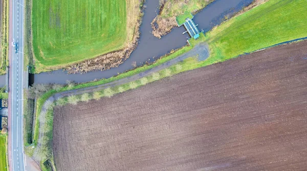 Vista dall'alto verso il basso, ripresa con un drone del Paesaggio con strada e ponti sul fiume Aa, Erzegovina, Belgio, che corre tra i campi coltivati — Foto Stock