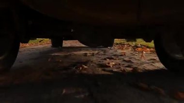 SUV kamyonunun arka tekerlekleri dönüyor ve karanlık, kirli toprak ve bulanık titreşimli arazi üzerinde hareket ediyor.