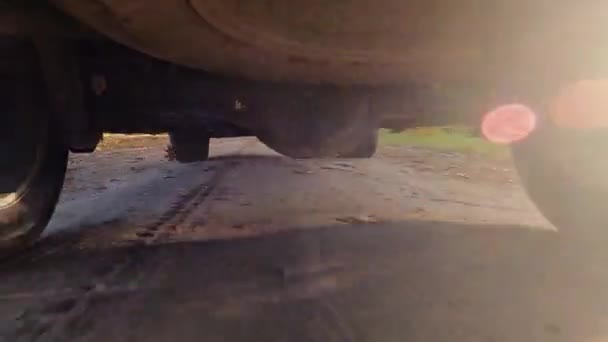 Задні колеса позашляховика обертаються і рухаються по бездоріжжю з сутінковою брудною землею і розмитим струмом — стокове відео