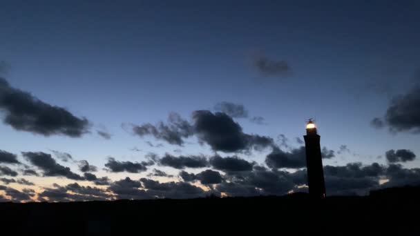 Vue du phare d'Ouddorp, Pays-Bas la nuit. Il montre un ciel sombre avec une teinte de lila en arrière-plan et un phare lumineux. — Video