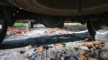 SUV kamyonunun arka tekerlekleri dönüyor ve karanlık, kirli toprak ve bulanık titreşimli arazi üzerinde hareket ediyor.