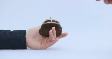 Erkek el, kripto, Bitcoin ya da BTC 'yi küçük kahverengi bir cüzdana koyar, şifreleme ya da kripto veya kripto para ile para kazanmayı ya da ödemeyi tasvir eder ve tasarruf eder, elinde tutar ya da saklar.