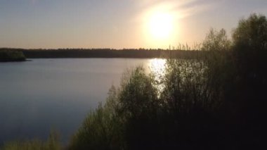Orman ve Sunset 'te ağaçlarla çevrili su yansıması olan güzel Manzaralı Göl Manzarası. Hava Aracı Atışı. Beerse, Belçika yakınlarında çekilmiş. 4K