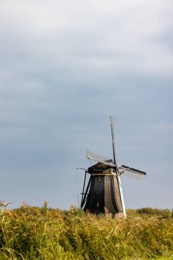 UNESCO 'nun dünya mirası sitesi Kinderdijk' teki ünlü Hollanda yel değirmenlerinden birinin dikey resmi. Fotoğraftaki 19 değirmenden biri Kinderdijk, Güney Hollanda, Hollanda 'daki