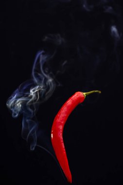 Siyah arka planda kırmızı kırmızı kırmızı biberler. Dumanı tüten sıcak kırmızı biberler.